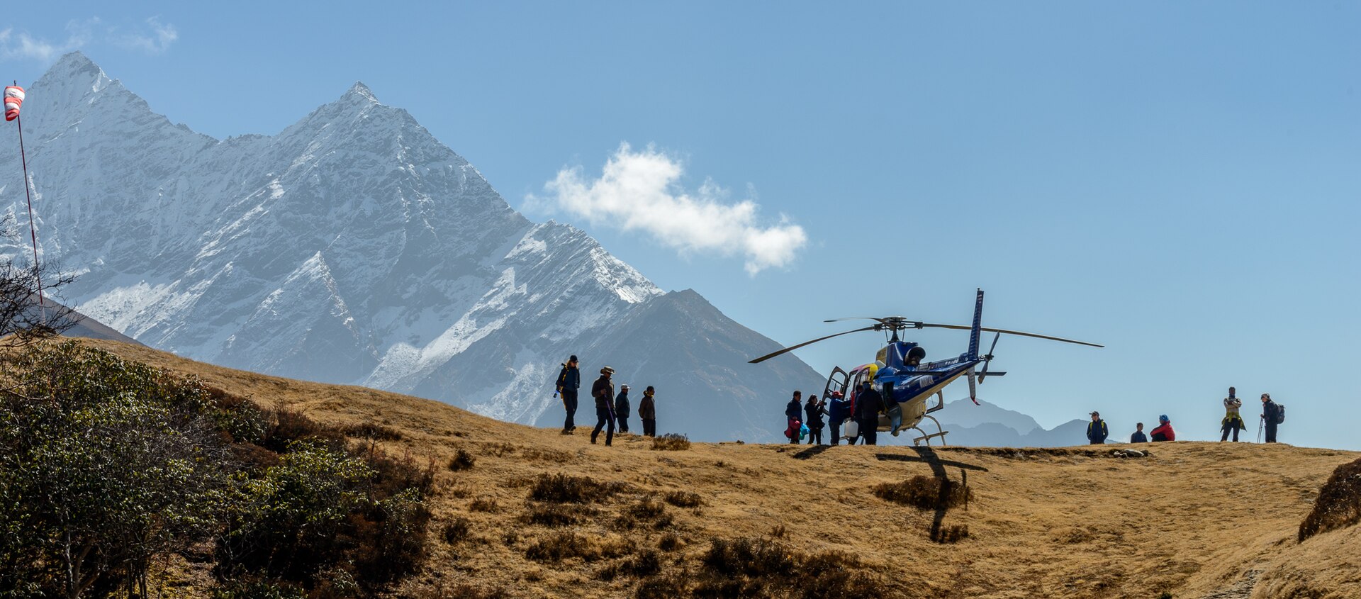 A helicopter evacuating a trekker suffering altitude sickness from a Himalayan valley.