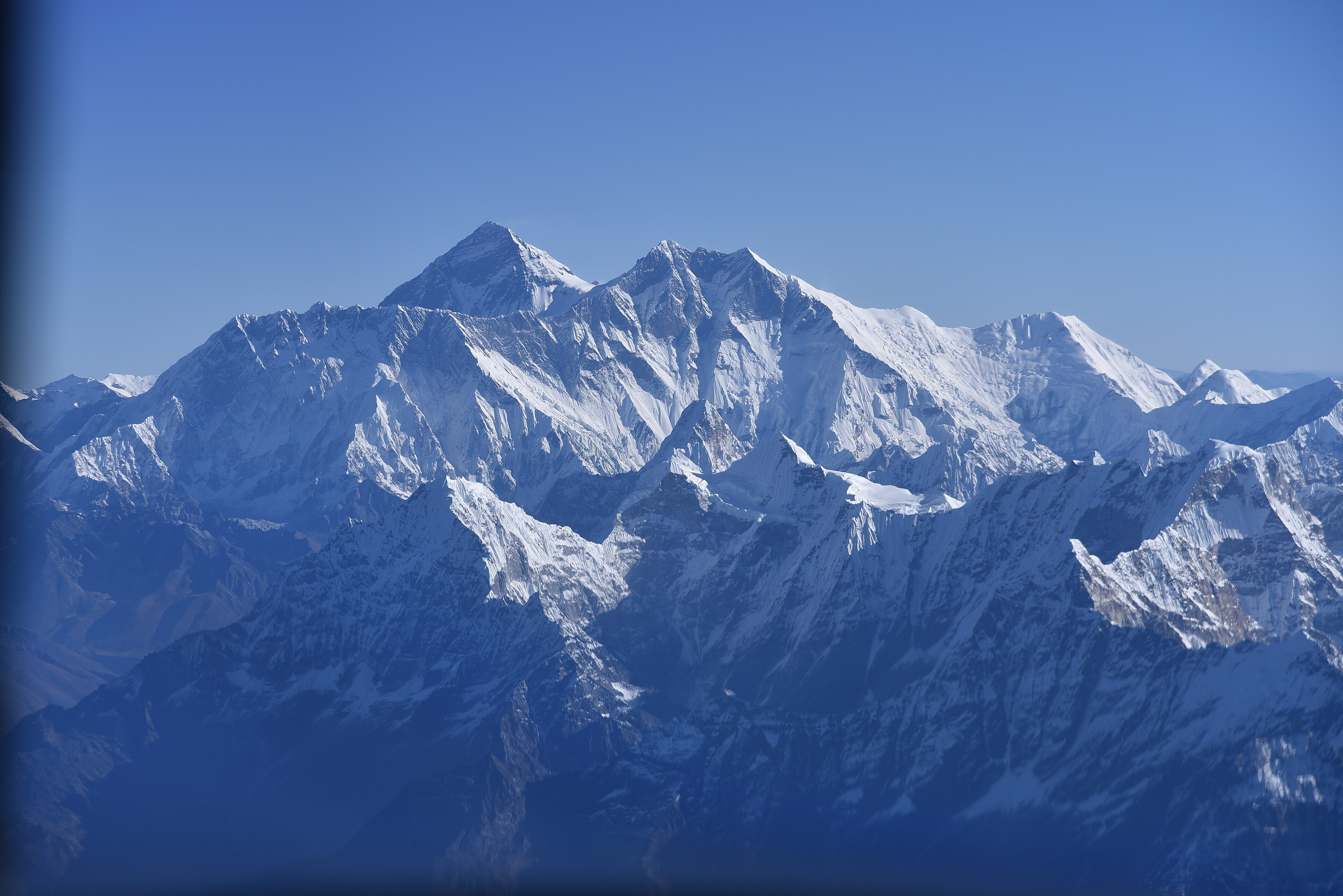 Everest and Lhotse from cruise altitude, seen through a helicopter cabin window.